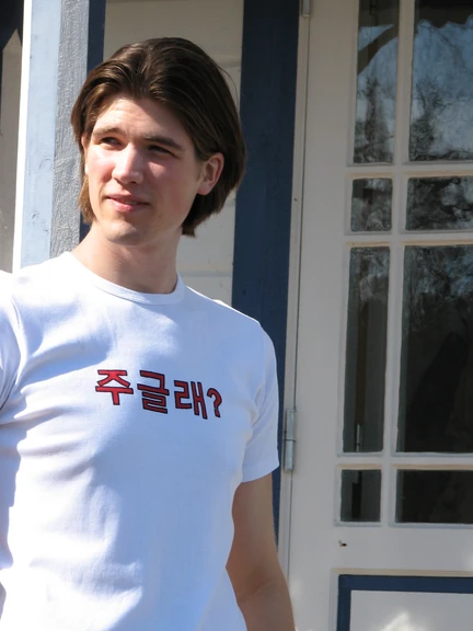 Wanna die? Philip wearing a white t-shirt with red Korean print