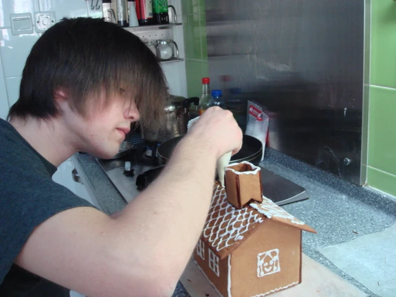 Philip dekorerar ett pepparkakshus